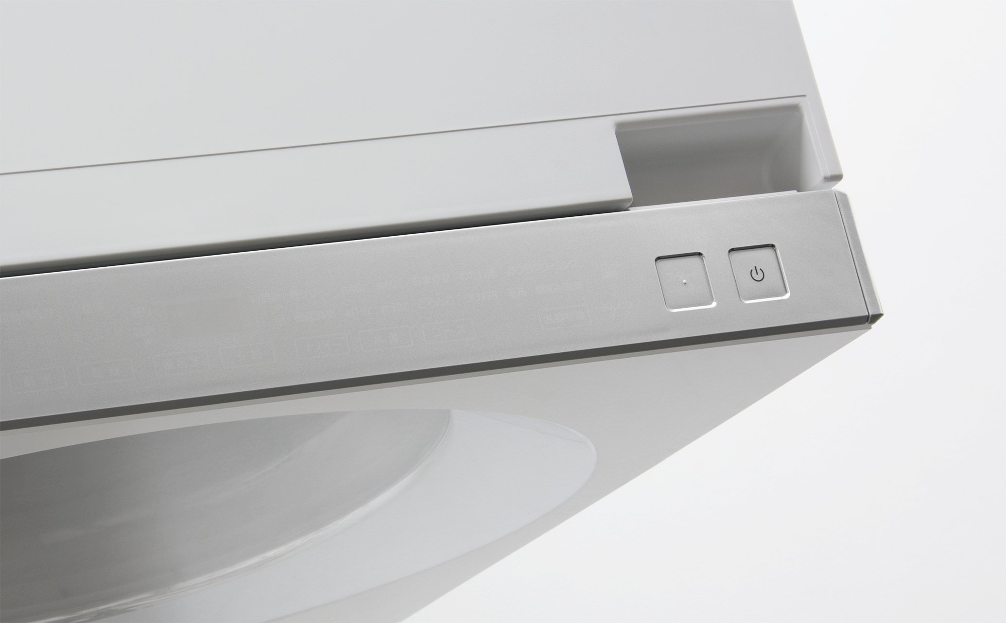 Front corner of a silver washing machine with control buttons, viewed from above against a white background
