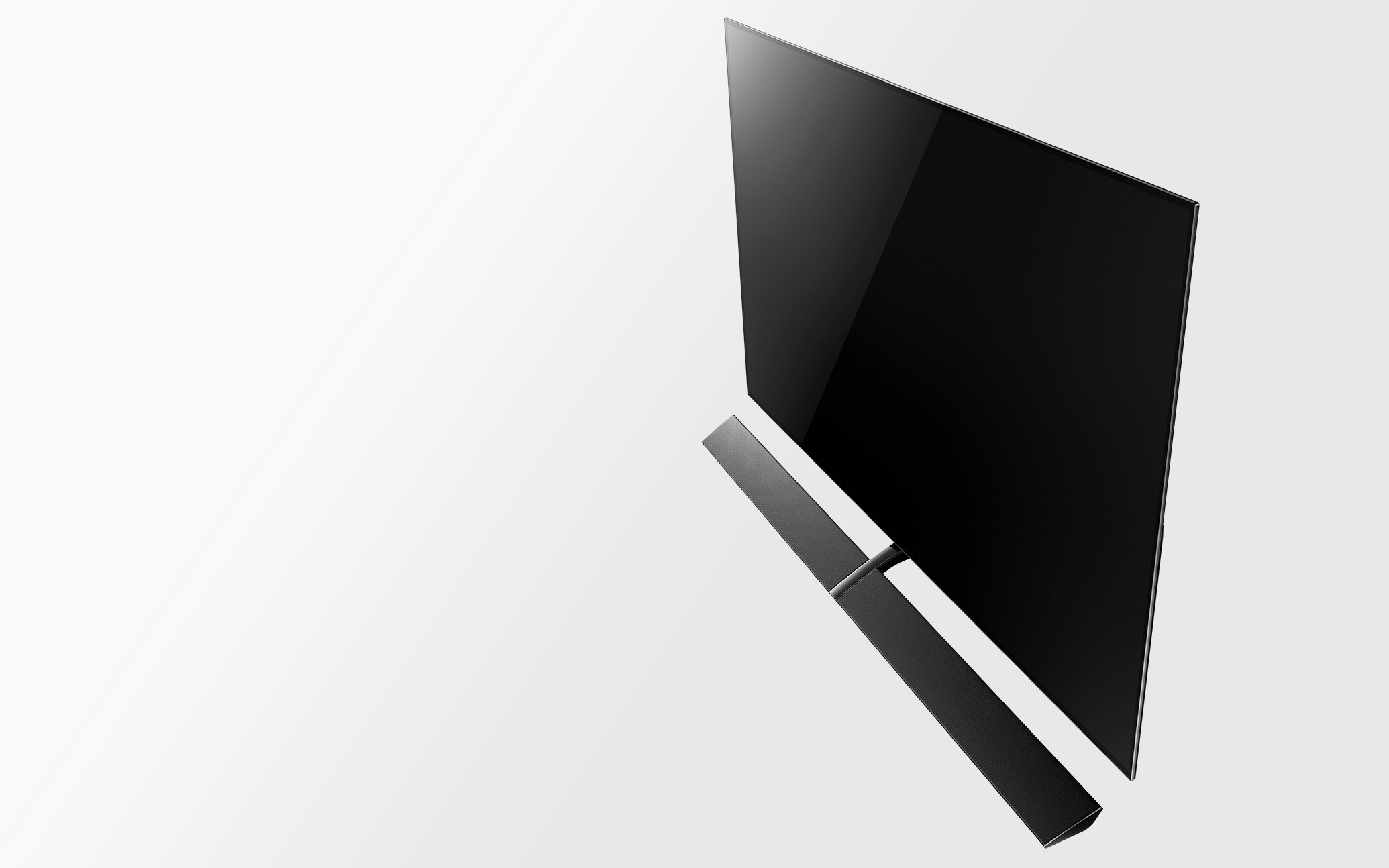 A modern flat-screen television with a soundbar placed below it, viewed from above against a white background.