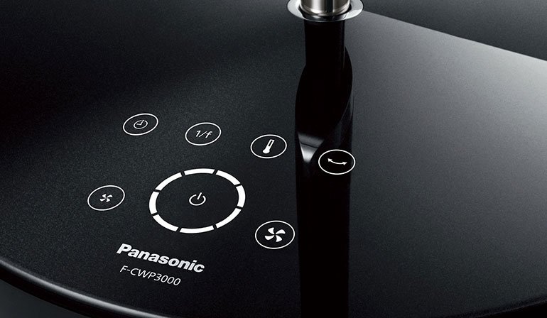 A close-up of the control panel on a fan's base, featuring buttons for power, speed, and oscillation.