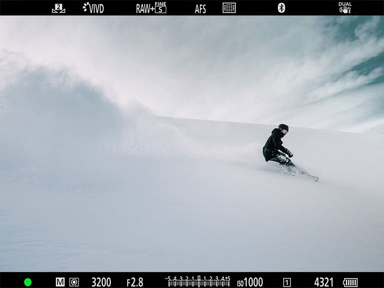 Silhouette of a skier gliding on snow with a vast blue sky in the background