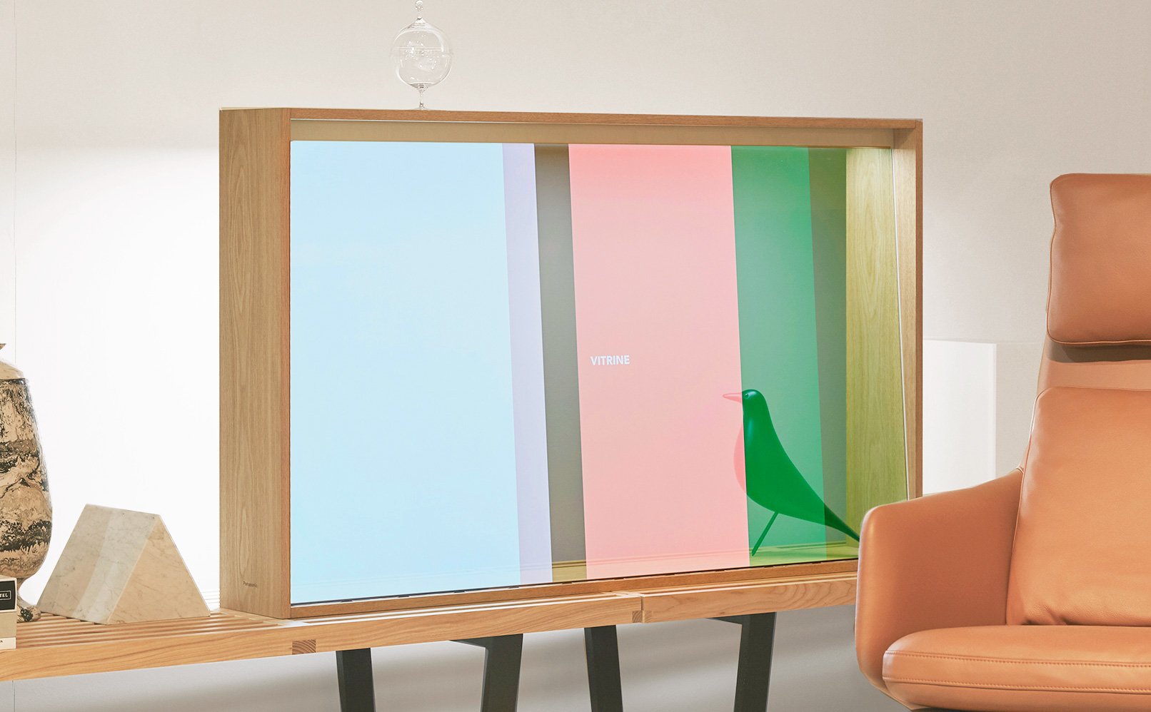 Wooden frame clear display with a green bird ornament and 