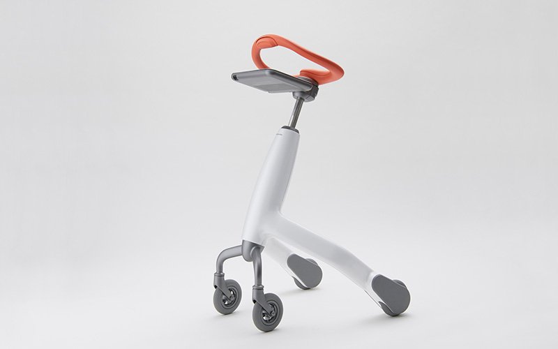  Three-wheeled walking training robot in white. Orange handlebar, grey tablet mount, white main body. Grey caster wheels. Photographed on white background