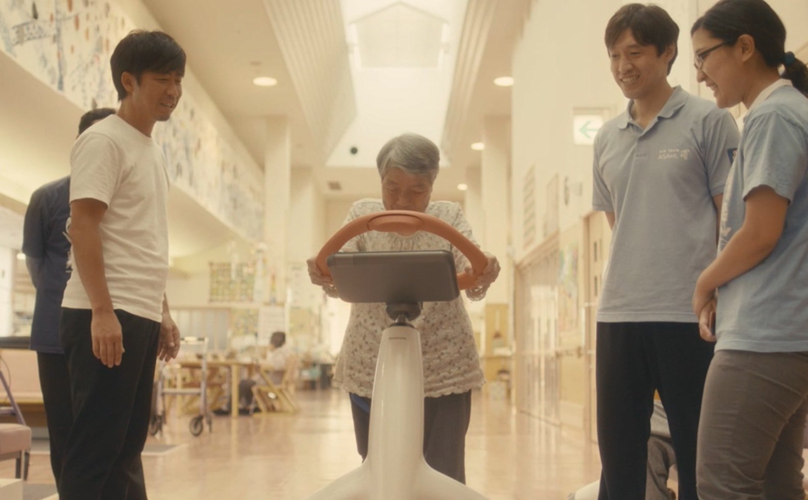 Walking training robotMultiple people surrounding a person being trained.