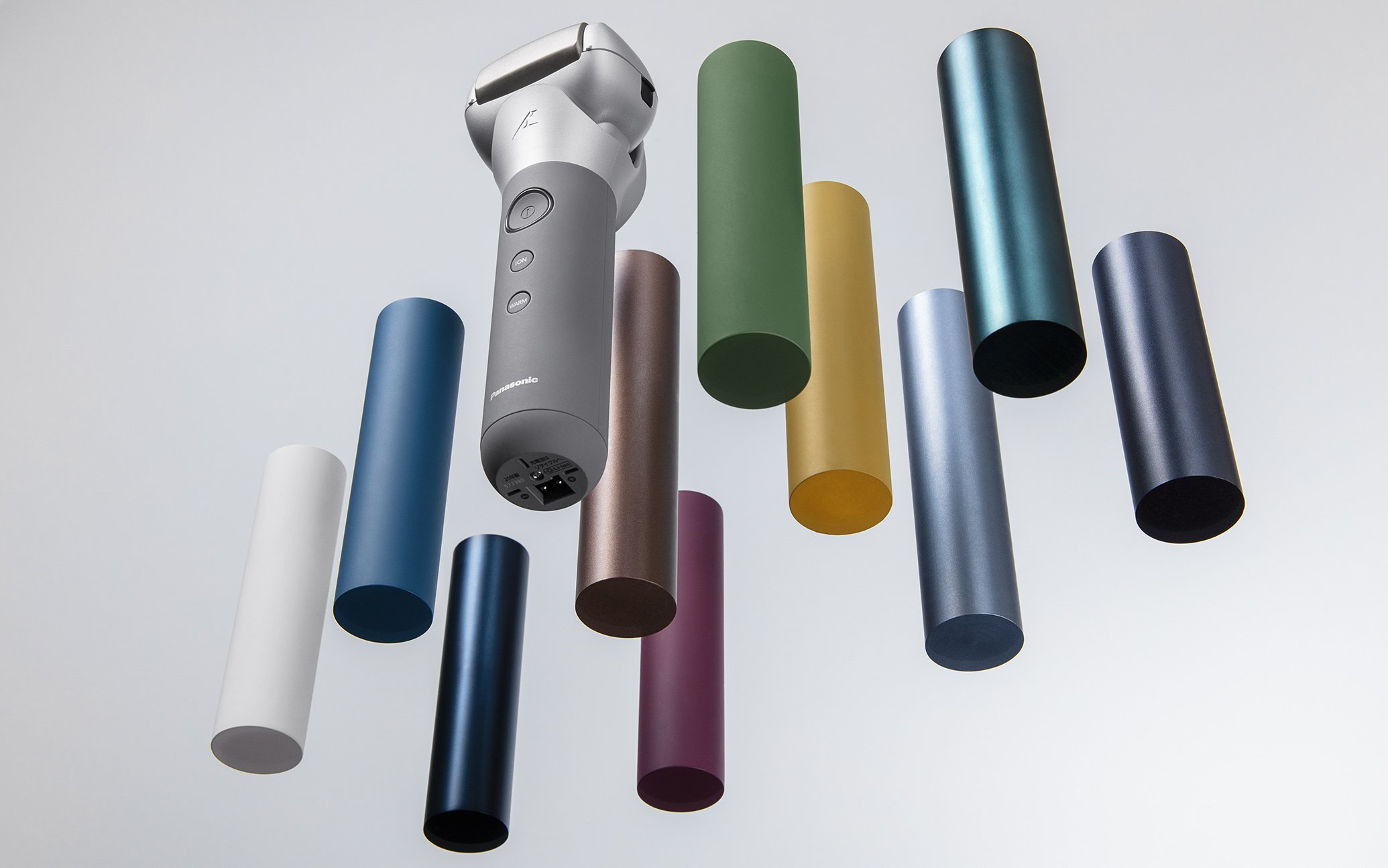 Front view of a gray handheld vacuum cleaner surrounded by colorful cylinders, top-down perspective