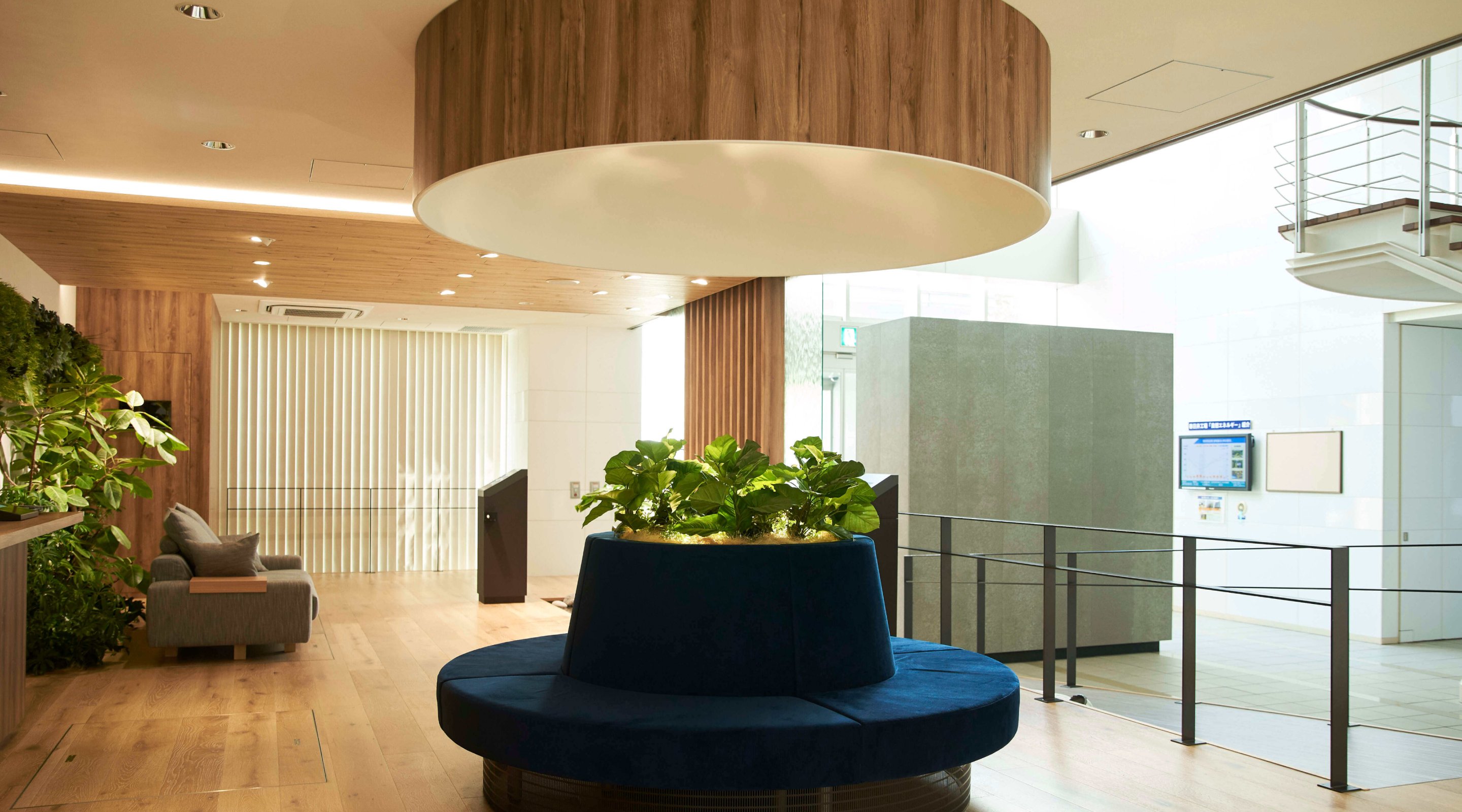 Space with a blue circular sofa in the centre and a large hood above it.